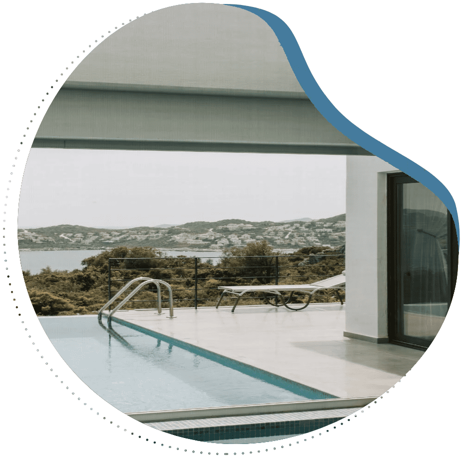 A pool with a view of the ocean and mountains.