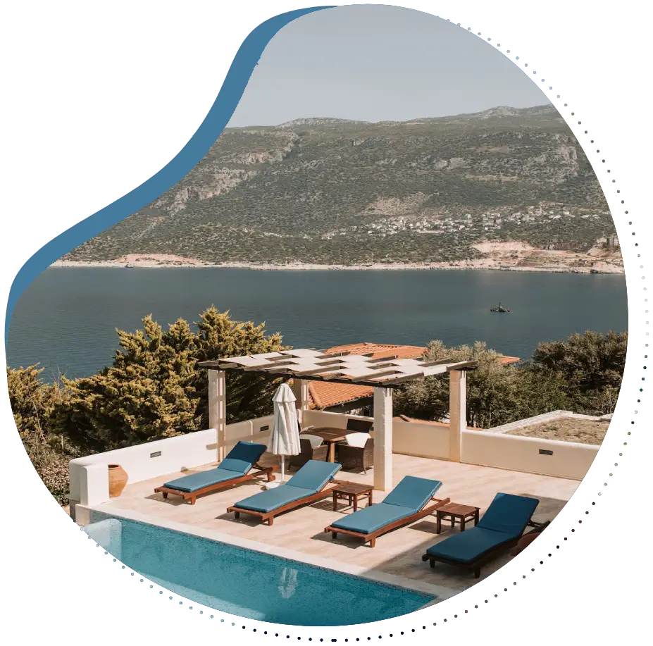 A pool with a view of the ocean and mountains.